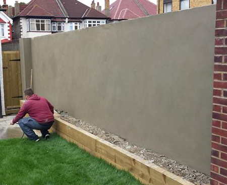 A man next to a freshly rendered garden wall in Croydon